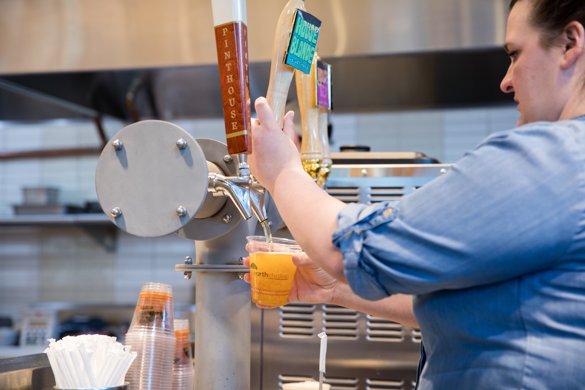 Server pouring beer from tap into a cup